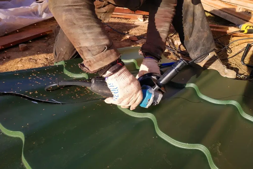 roofer cutting metal roofing sheet wearing safety gears