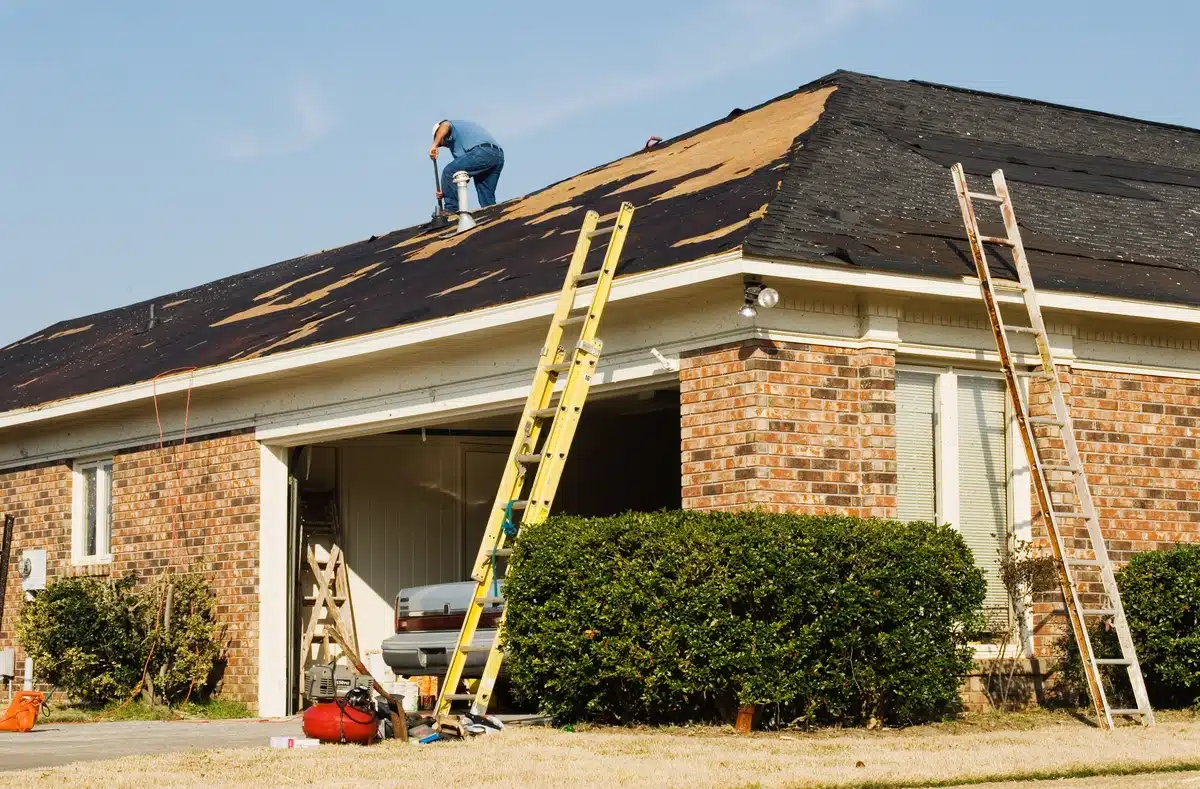 brick house roof replacement roof replacement process of the brick house and worker on the roof