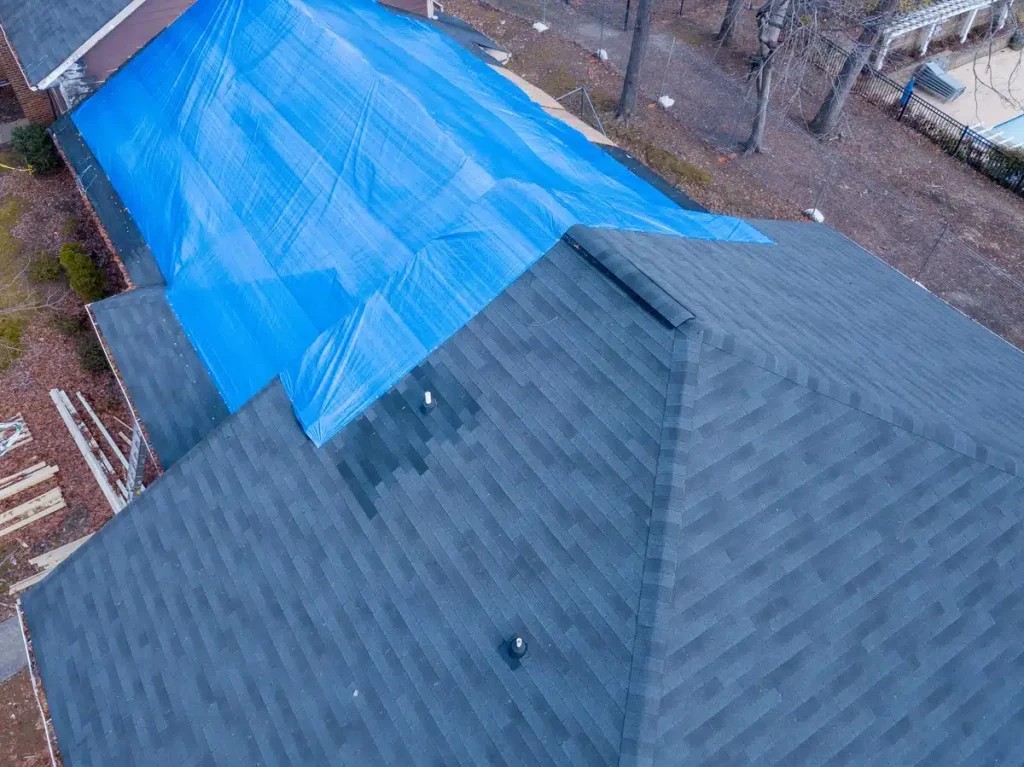 asphalt roof of the house covered with tarp from damage