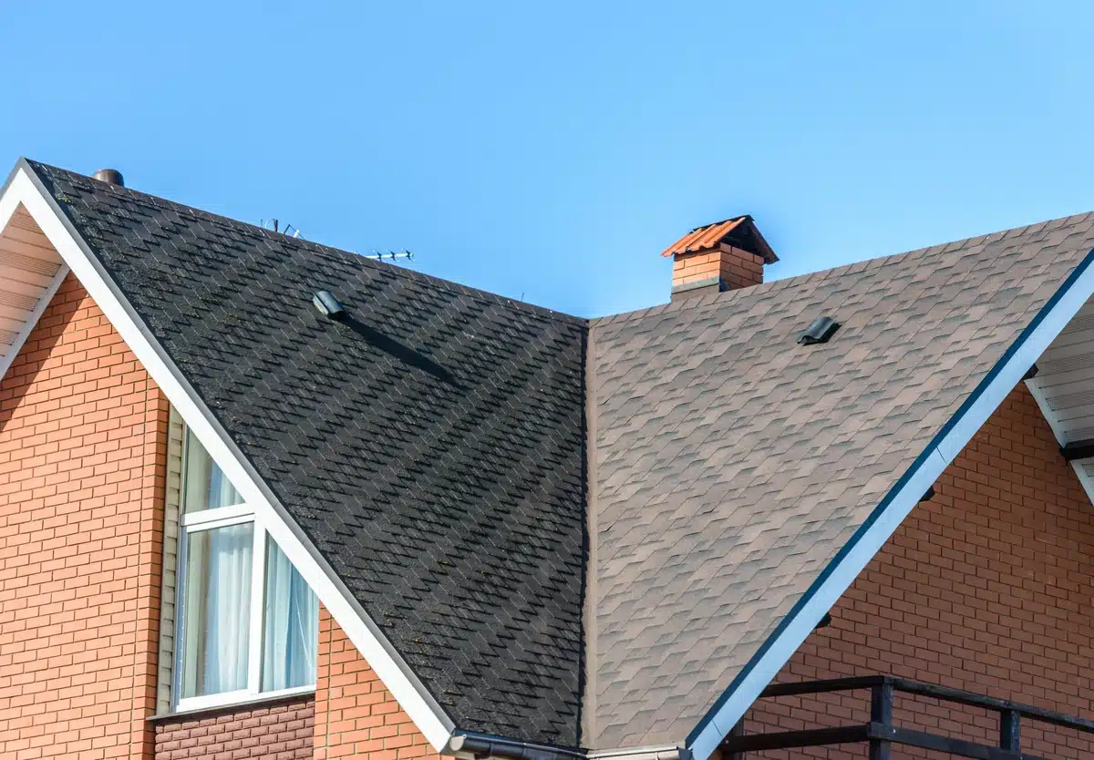 brick residential building roof house with asphalt shingle roof and vents on