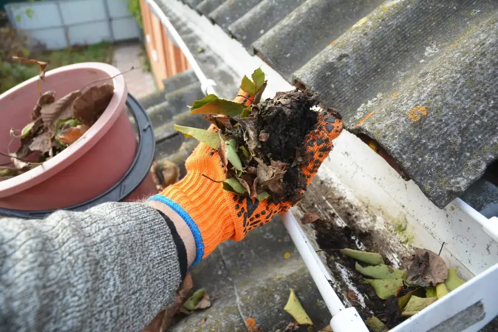 gutter debris being cleared out by hand