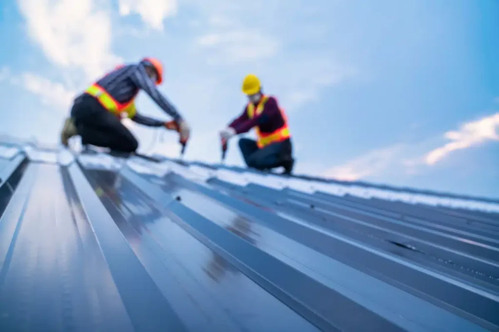 two roofers installing metal roofing