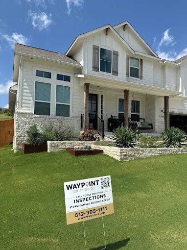 White two-story home with Waypoint Roofing yard sign
