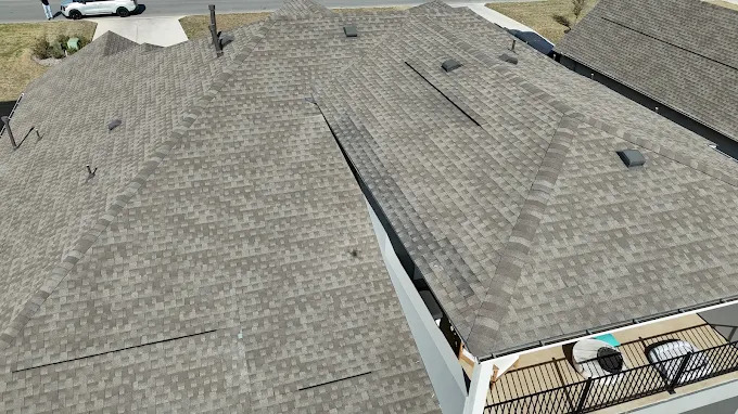 Close aerial view of shingle roof planes and vents