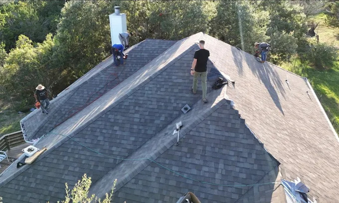 Roofing crew working on a shingle roof