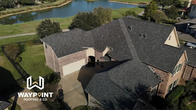 Dark shingle roof beside a pond