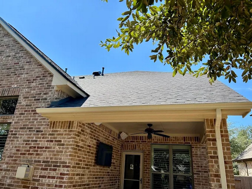 Shingle roof above a covered brick patio